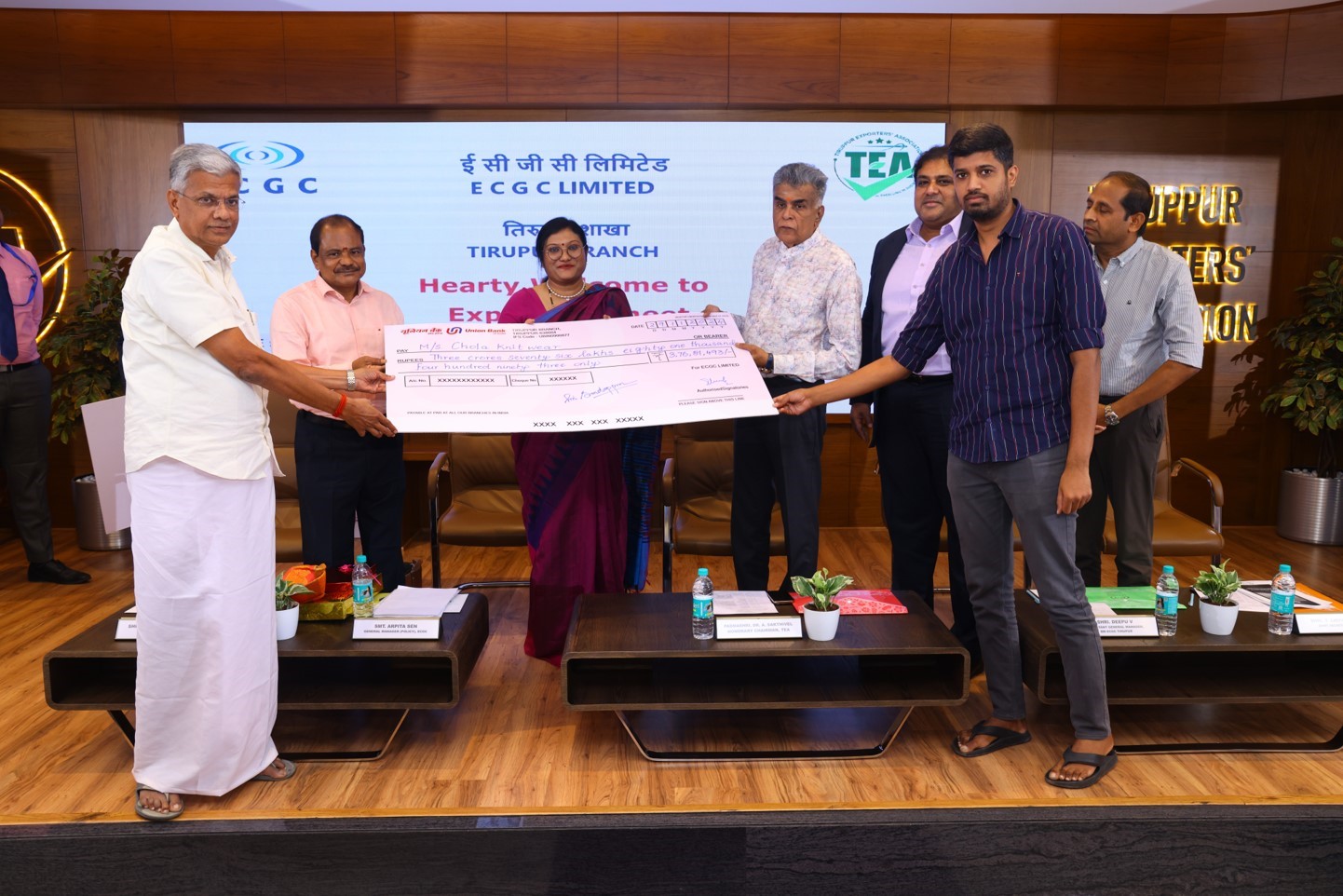 Image for CGC official handing over a cheque to CHOLA KNIT WEAR representative at Tirupur branch.